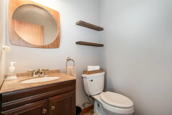 a bathroom with a toilet a sink and mirror