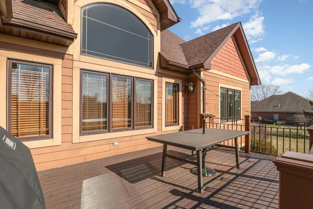 a view of a house with wooden deck and furniture