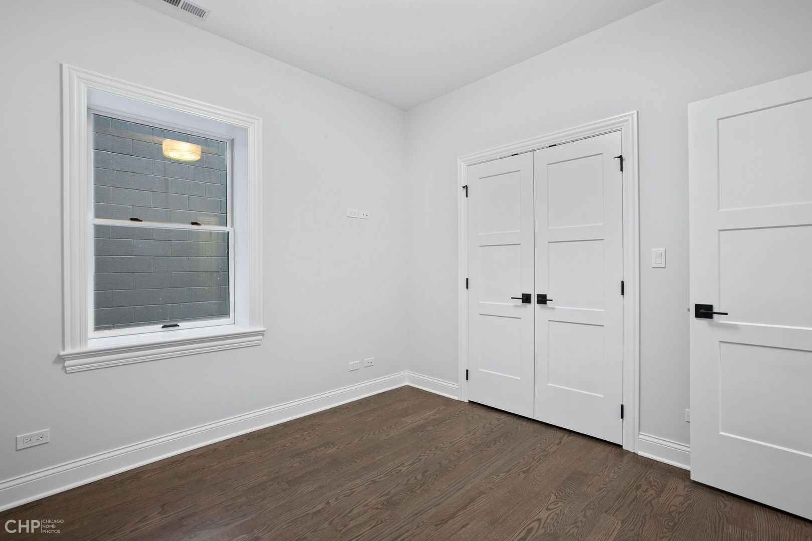 211 South Hamilton Avenue, Unit 2 Chicago, IL 60612 - Photo 11 of 16 a view of an empty room with wooden floor and a window