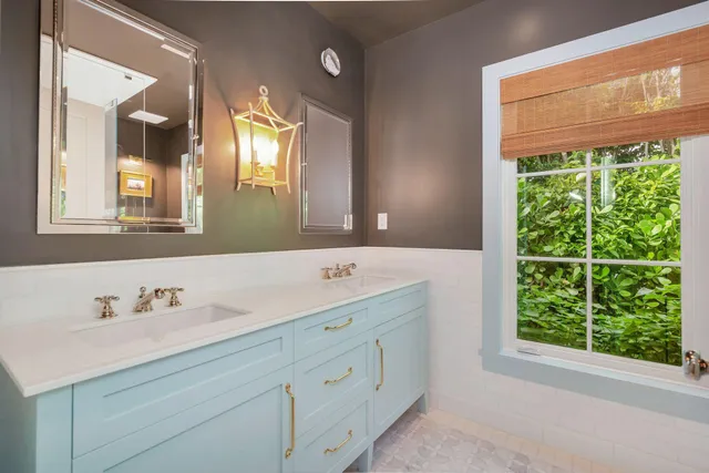 a bathroom with a double vanity sink window and mirror
