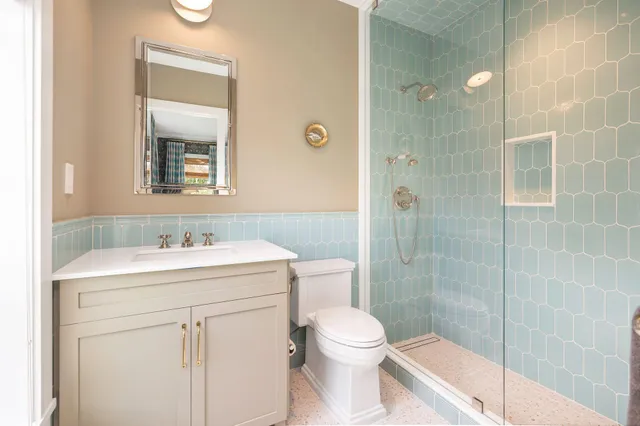 a bathroom with a sink a toilet and shower