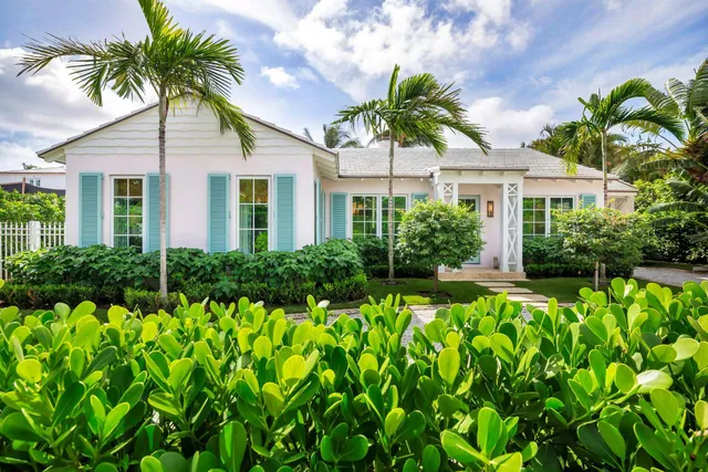 a front view of yellow house with a yard