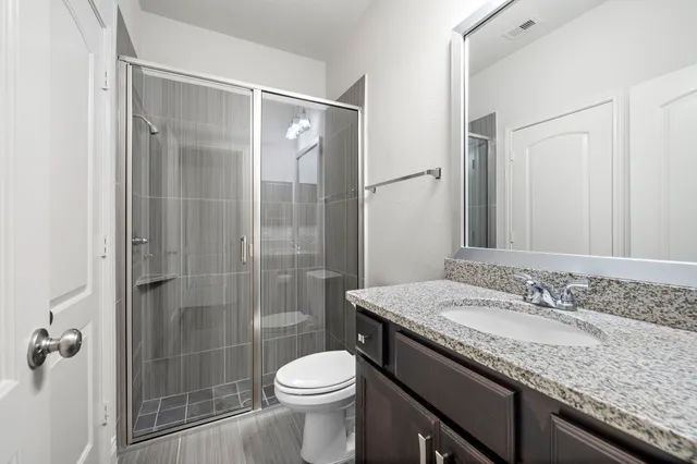 a bathroom with a granite countertop sink toilet and shower