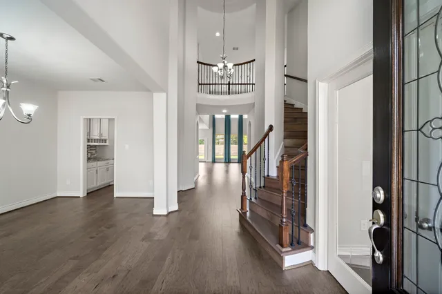 a view of a hallway with wooden floor and staircase