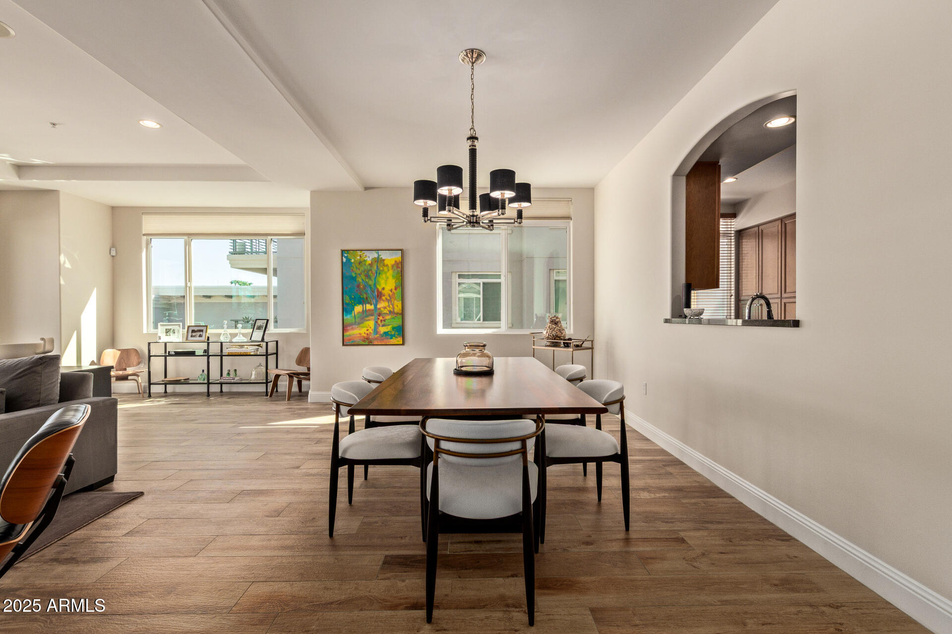 3801 North Goldwater Boulevard, Unit 302 Scottsdale, AZ 85251 - Photo 7 of 23 a view of a dining room with furniture wooden floor and chandelier