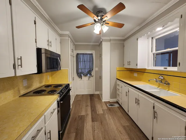 a kitchen with stainless steel appliances a stove cabinets and wooden floor
