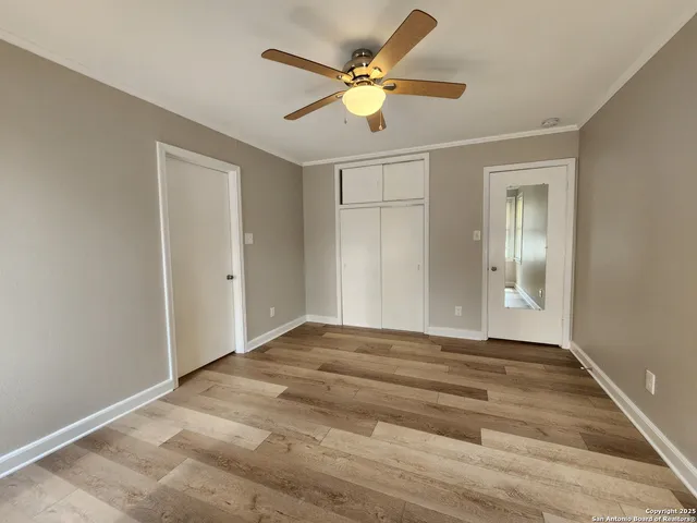 a view of an empty room with window and a ceiling fan