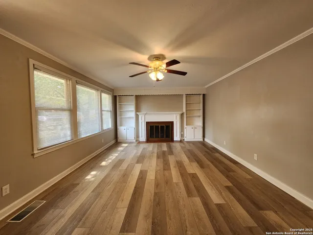 a view of an empty room with a fireplace and a window