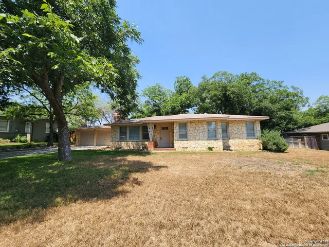 a front view of house with yard and trees