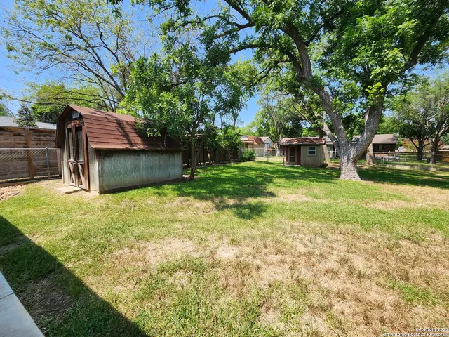 a backyard of a house with table and chairs