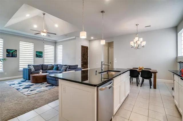 a kitchen island with granite countertop a sink and a couch