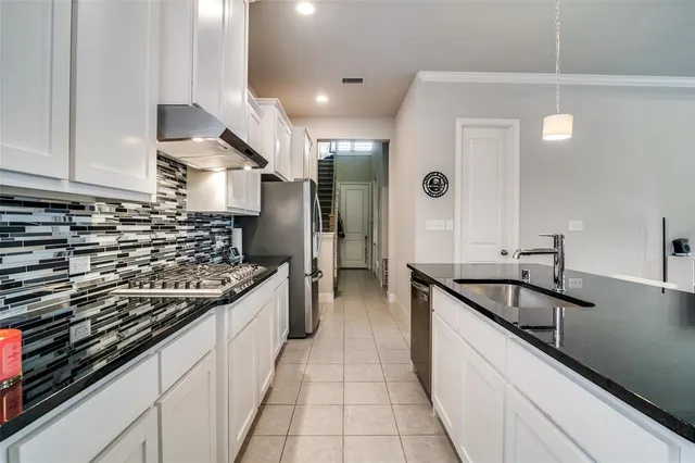a kitchen with granite countertop a sink and a stove top oven