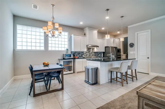 a kitchen with a dining table cabinets and appliances