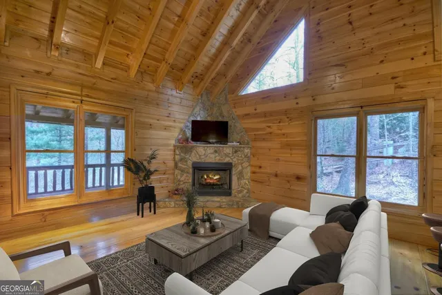 a living room with furniture a fireplace and a floor to ceiling window