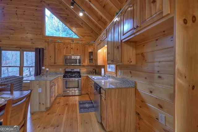 a kitchen with granite countertop stainless steel appliances and wooden cabinets