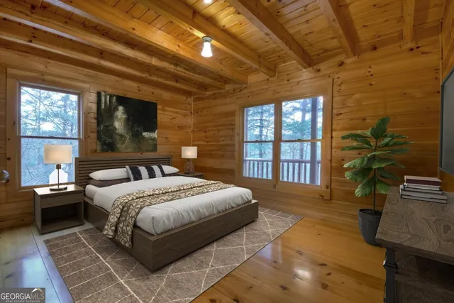 a bedroom with a large bed a flat tv screen and a potted plant