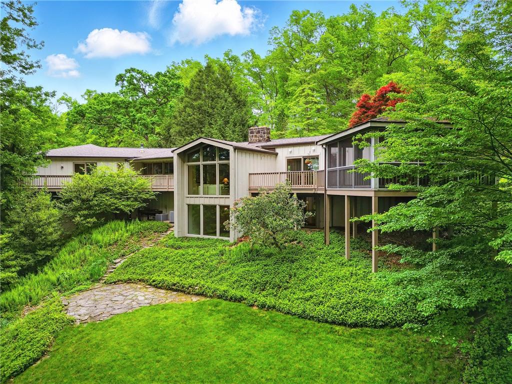 a front view of a house with a yard and trees