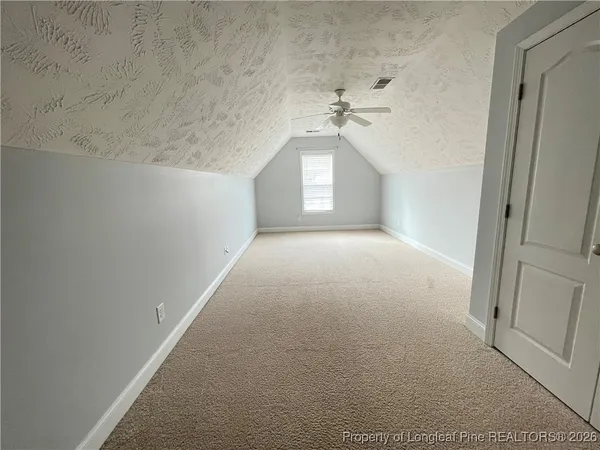 a view of a hallway with a chandelier fan and windows