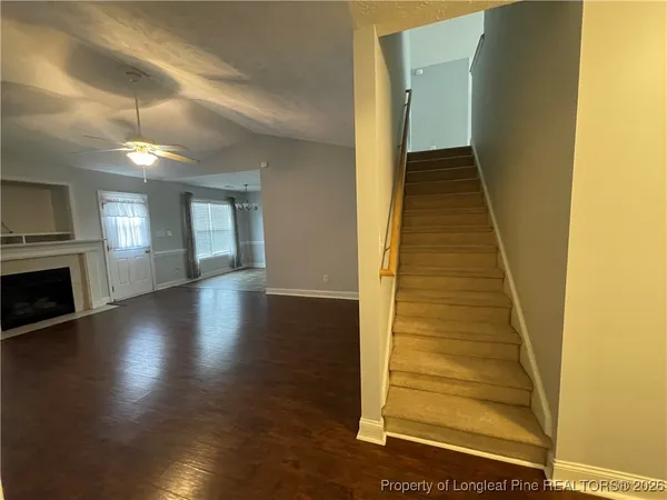 a view of a livingroom with wooden floor and staircase