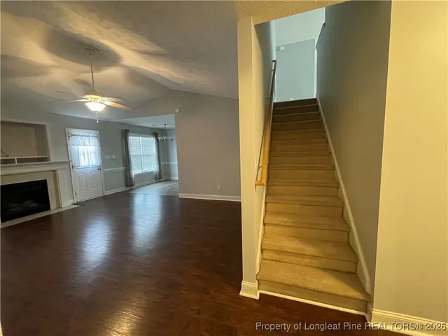a view of a livingroom with wooden floor and staircase