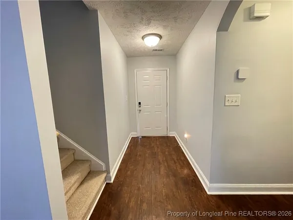 a view of a hallway with wooden floor and entryway