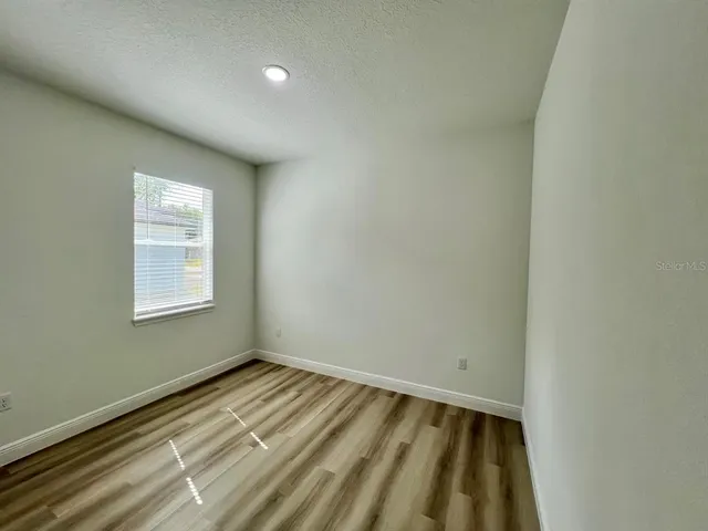 a view of a room with wooden floor and window