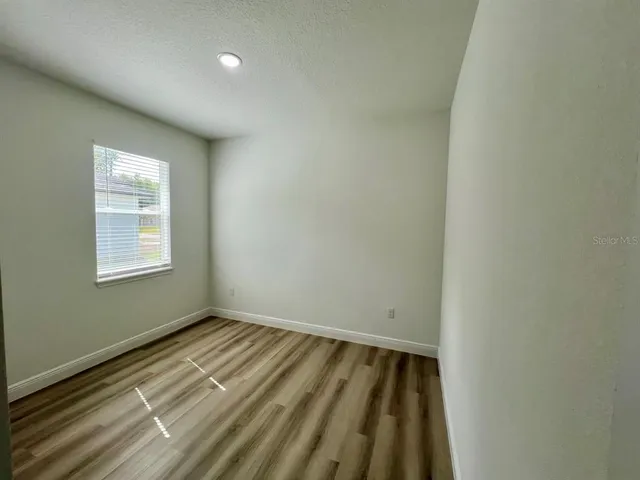 a view of a room with wooden floor and window