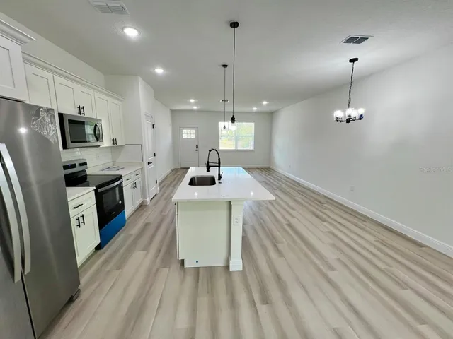 a kitchen with stainless steel appliances a refrigerator sink and cabinets