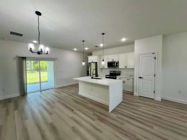 a view of kitchen with refrigerator microwave and stove