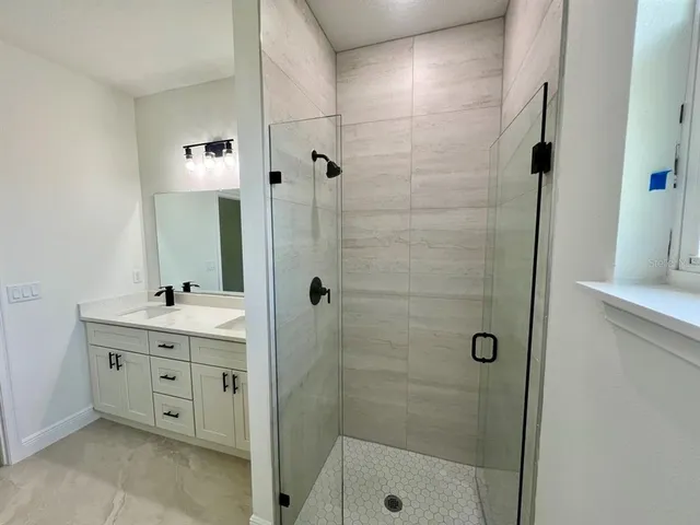 a bathroom with a shower sink and mirror