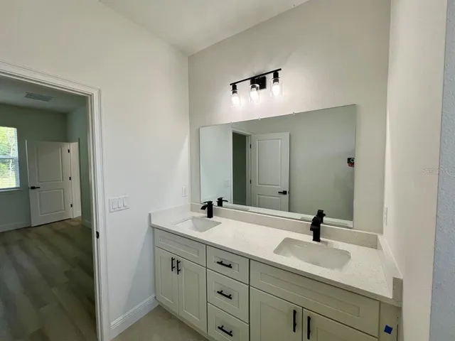 a bathroom with a double vanity sink and mirror