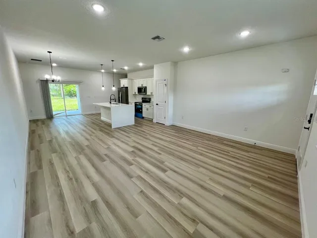 a view of kitchen and hall with wooden floor