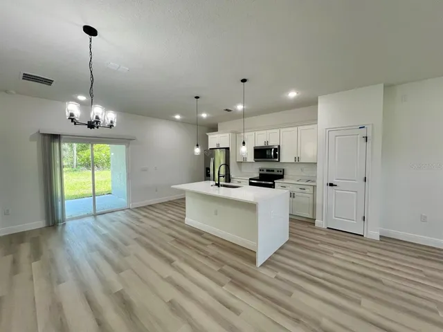 a view of kitchen with refrigerator microwave and stove