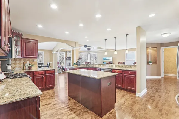 a kitchen with kitchen island granite countertop a sink stove and refrigerator