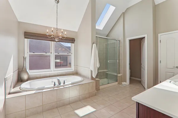a bathroom with a tub a sink and a window