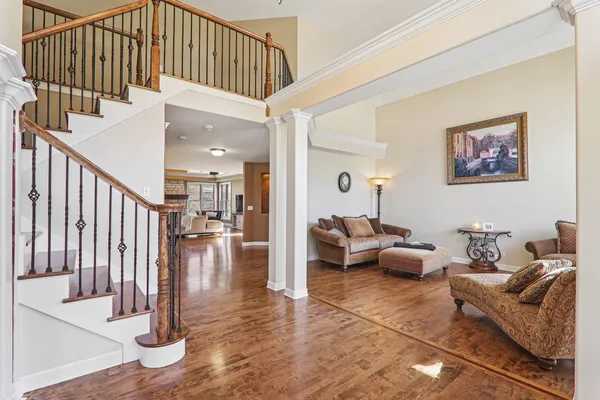 a living room with couches painting on the wall with wooden floor