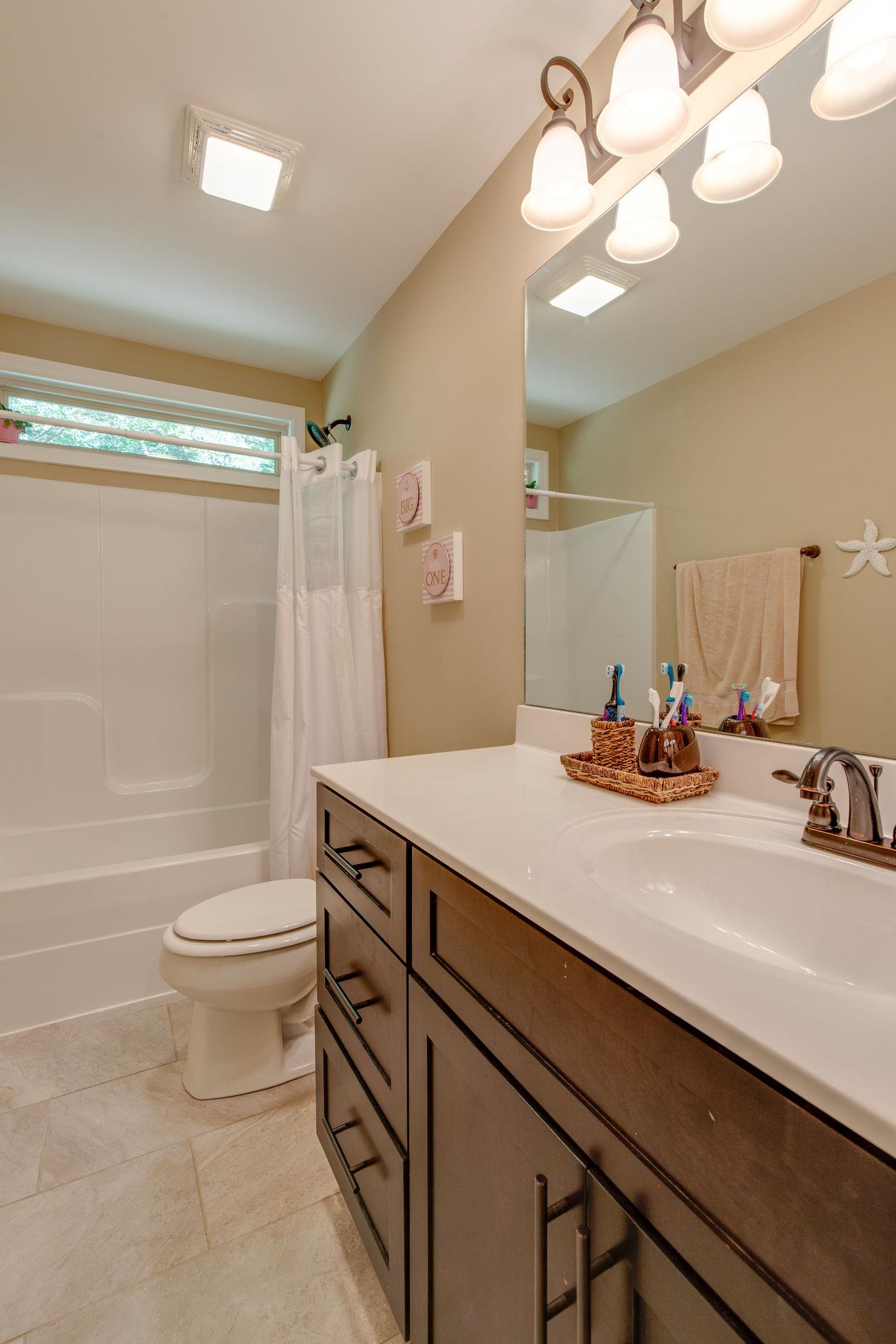 67 Remington Road Lebanon, TN 37090 - Photo 21 of 26 a bathroom with a sink a toilet a mirror and shower