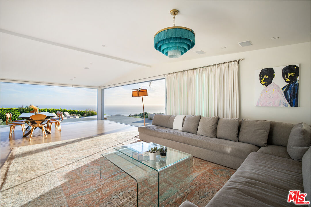 22407 Carbon Mesa Road Malibu, CA 90265 - Photo 11 of 33 a living room with furniture and a large window