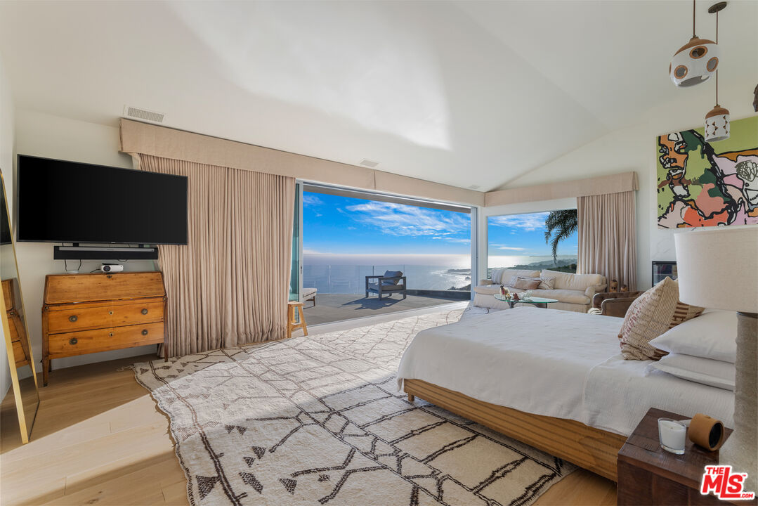 22407 Carbon Mesa Road Malibu, CA 90265 - Photo 13 of 33 a bedroom with a bed and flat screen tv