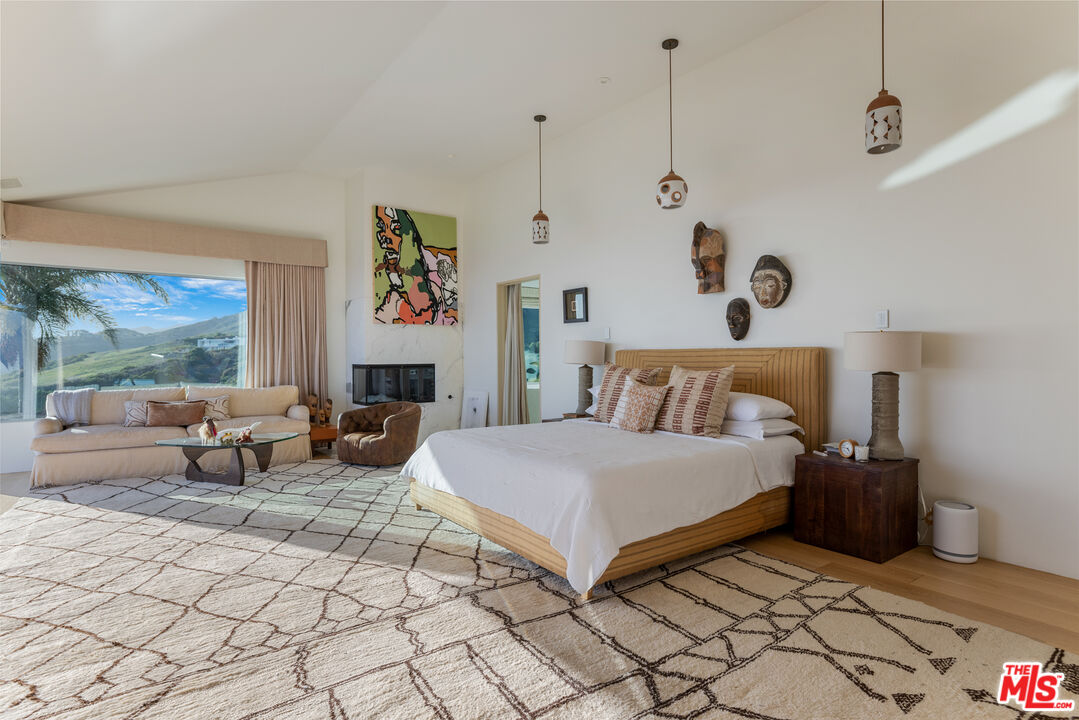 22407 Carbon Mesa Road Malibu, CA 90265 - Photo 14 of 33 a spacious bedroom with a large bed and a couch