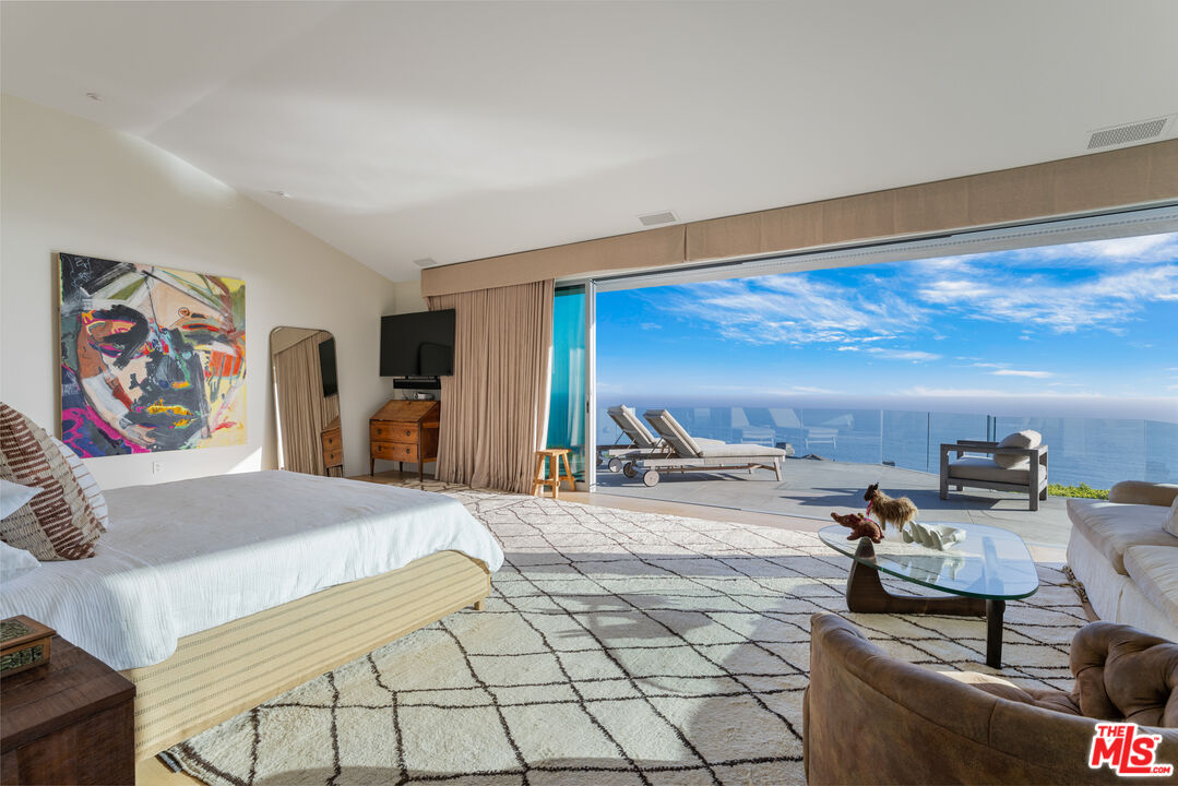 22407 Carbon Mesa Road Malibu, CA 90265 - Photo 15 of 33 a bedroom with furniture and view of living room