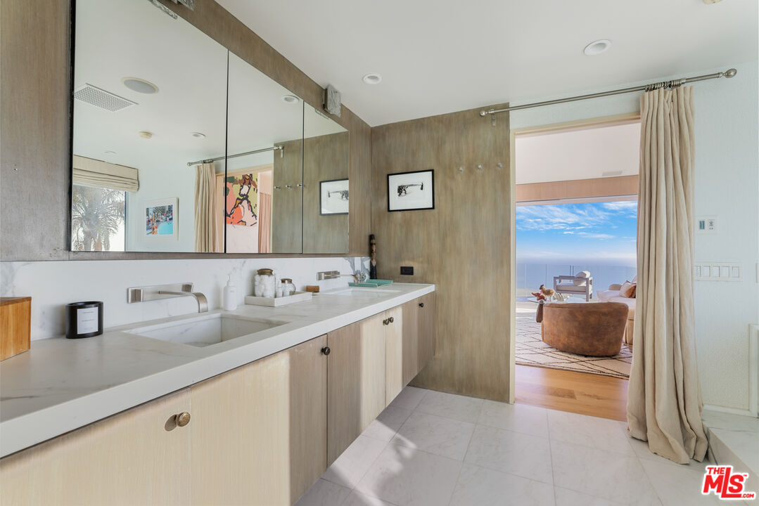 22407 Carbon Mesa Road Malibu, CA 90265 - Photo 16 of 33 a bathroom with a double vanity sink and a mirror