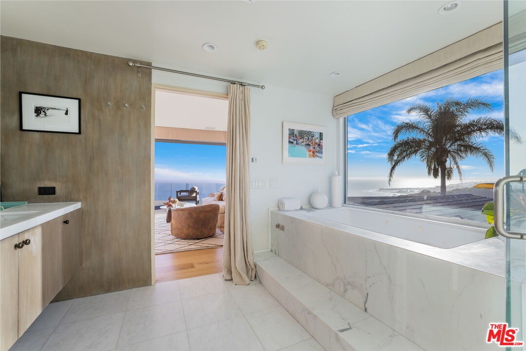 22407 Carbon Mesa Road Malibu, CA 90265 - Photo 17 of 33 a bedroom with a bed and a view of living room