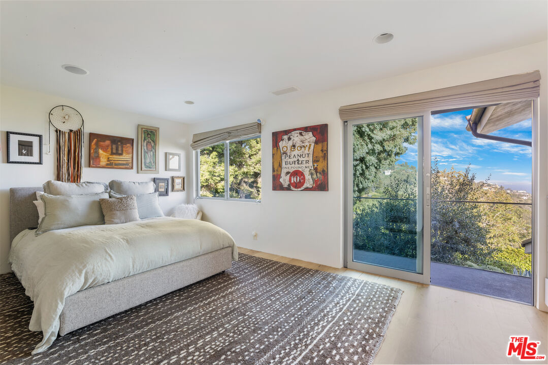 22407 Carbon Mesa Road Malibu, CA 90265 - Photo 20 of 33 a bedroom with a large bed and a window