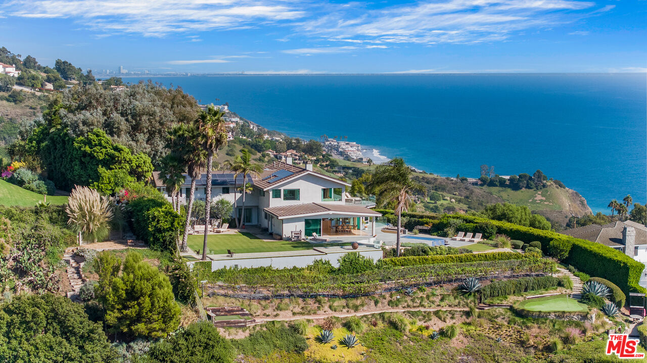 22407 Carbon Mesa Road Malibu, CA 90265 - Photo 2 of 33 a front view of a house with a yard