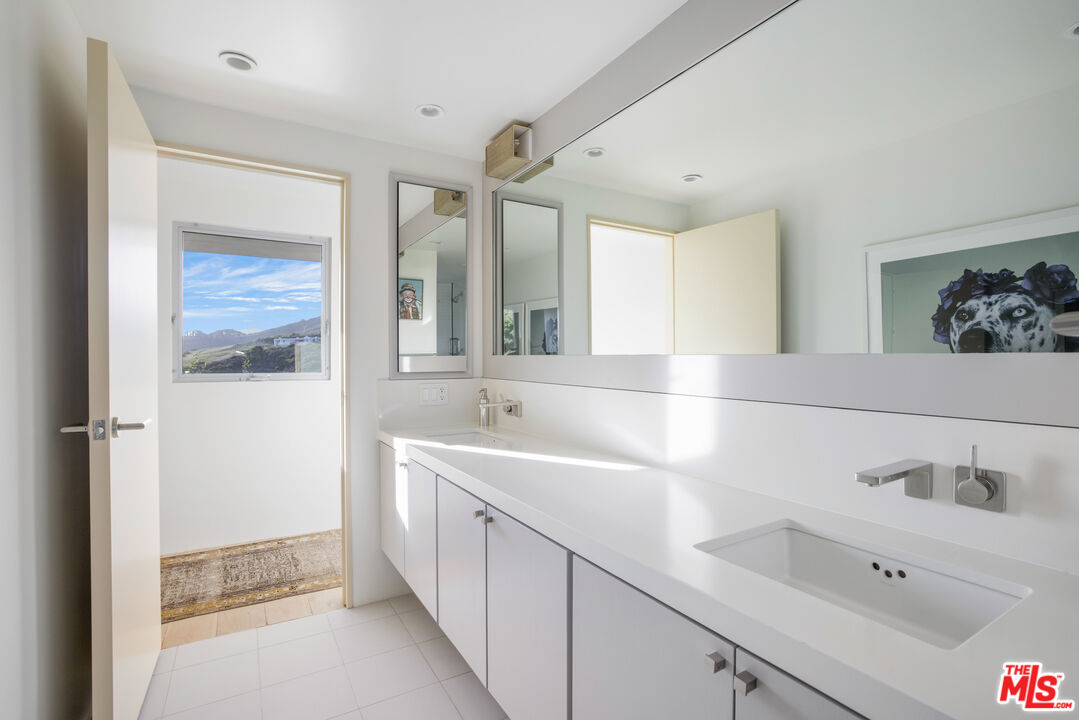 22407 Carbon Mesa Road Malibu, CA 90265 - Photo 21 of 33 a bathroom with a sink and a bathtub