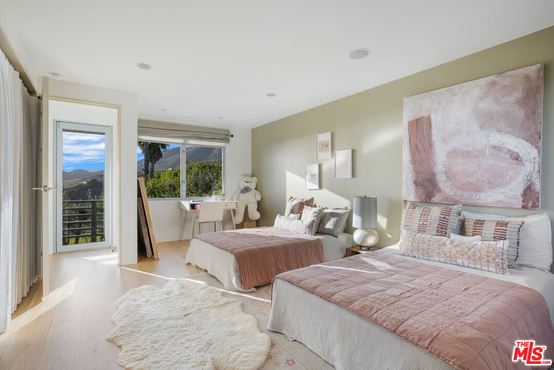 22407 Carbon Mesa Road Malibu, CA 90265 - Photo 22 of 33 a bedroom with two beds and large window