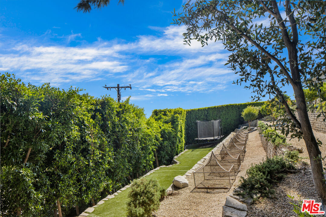 22407 Carbon Mesa Road Malibu, CA 90265 - Photo 29 of 33 a view of a yard with plants and a bench