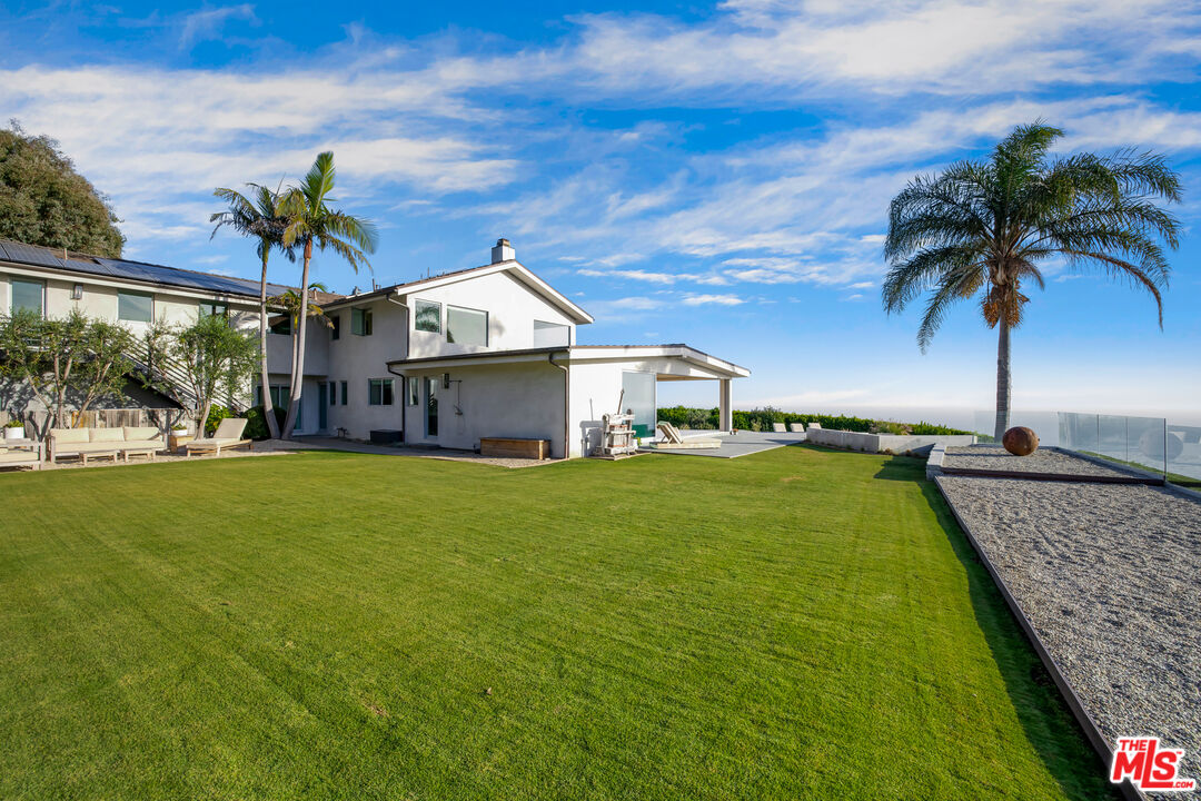 22407 Carbon Mesa Road Malibu, CA 90265 - Photo 30 of 33 a front view of a house with a garden and yard