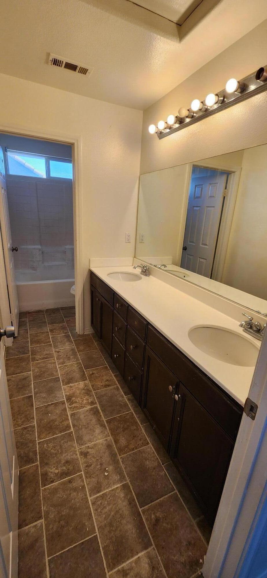 5817 Gem Court Lancaster, CA 93536 - Photo 19 of 26 a bathroom with a sink mirror and a shower